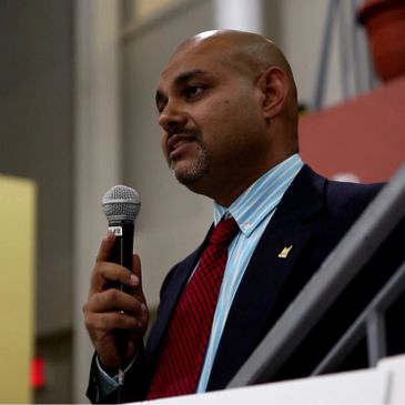 Man in suit speaking into a microphone.