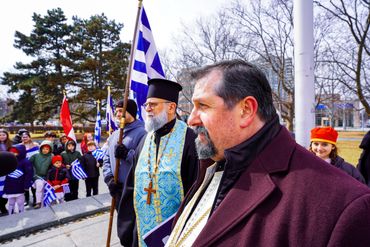 Men participating in a Greek cultural event outdoors.
