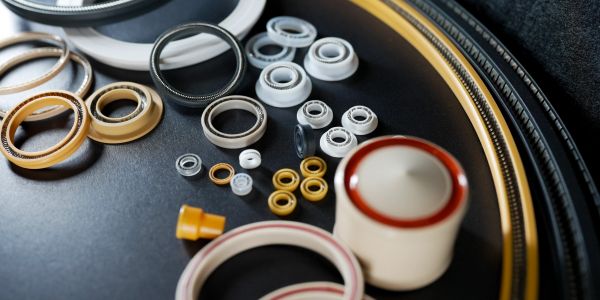 Assorted mechanical seals and gaskets on a dark surface.