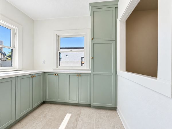 Altadena kitchen with sage pantry cabinetry, brass knobs, light countertops and recessed lighting.
