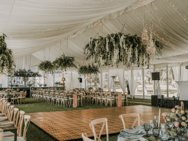 Elegant indoor reception with wooden chairs and floral decor.