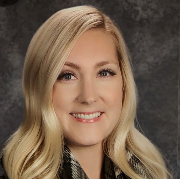 Smiling blonde woman with wavy hair.