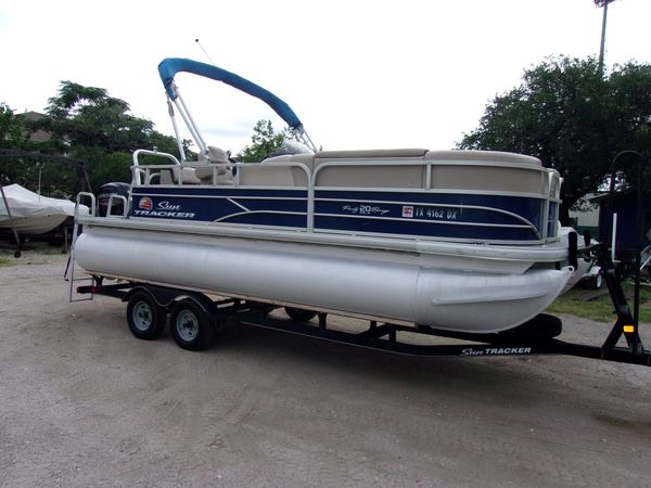 Pontoon boat on a trailer, ready for transport.