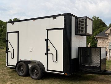 A white trailer with two doors and an air conditioning unit on the front.