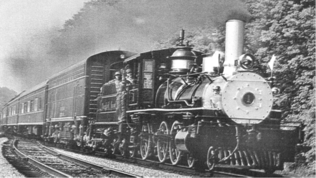 Black and white photo of a vintage steam locomotive pulling passenger cars.