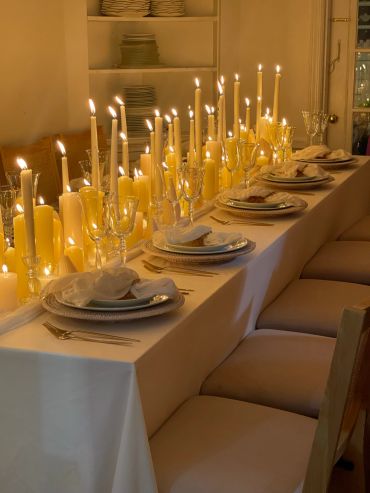 Elegant dinner table set with candles and plates.