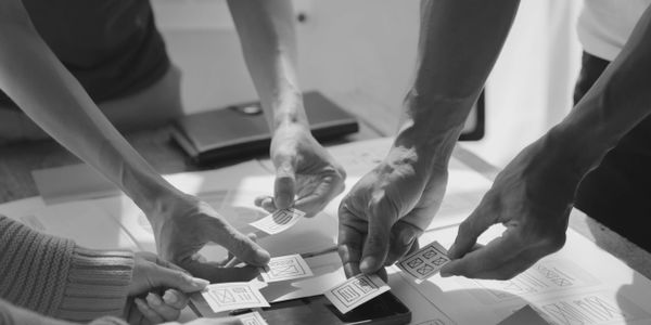 People collaborating on a project with paper wireframes.