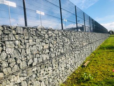 Gabion wall with open mesh fencing