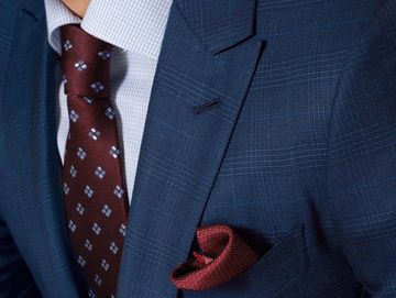 Close-up of patterned burgundy tie and matching pocket square on man in suit