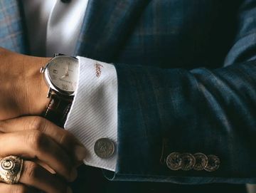 Close-up of cuff links and other accessories on man in suit