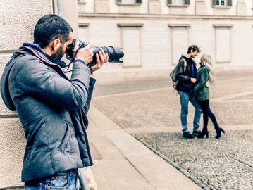 Photographer capturing a couple in an urban setting.