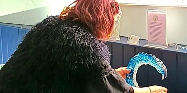 a woman placing a glass sculpture on a table