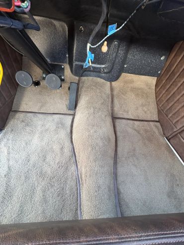 Car floor with pedal and carpet.