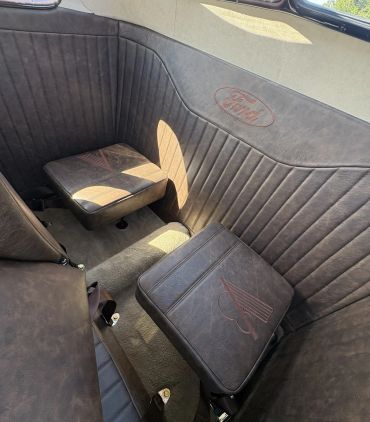 Vintage car interior with custom Ford logo upholstery.