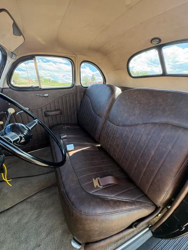 Interior of a vintage car with brown leather seats.