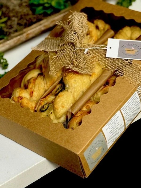 A gift box with baked goods and a decorative burlap ribbon.