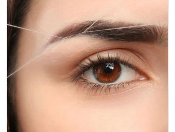 Getting her brows shaped by threading.
