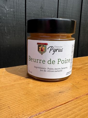 Jar of pear butter labeled 'Beurre de Poire' on a wooden surface.