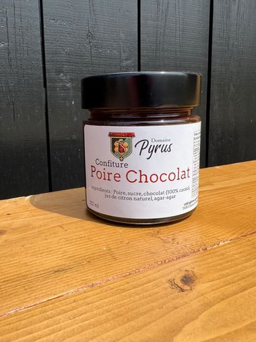 Jar of Poire Chocolat jam from Domaine Pyrus on a wooden surface.