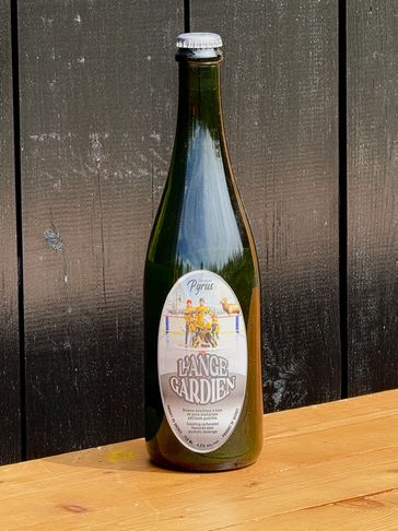 A green bottle of L'Ange Gardien beer on a wooden table.