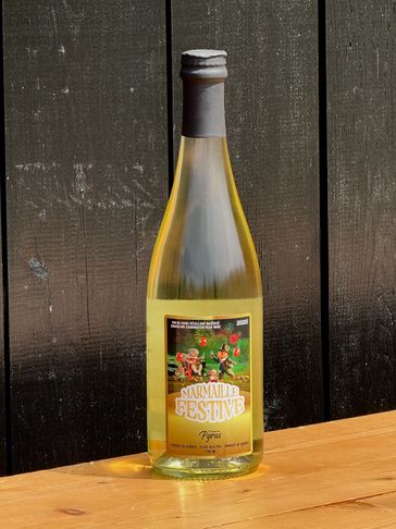 A bottle of Marmaille Festive white wine on a wooden table.