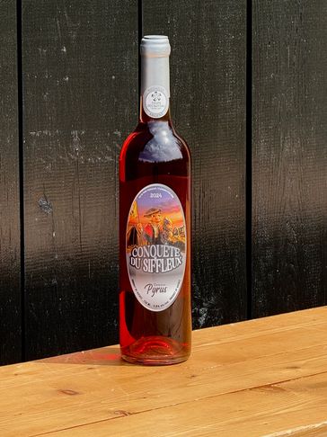 A bottle of rosé wine labeled Conquête du Siffleur on a wooden surface.