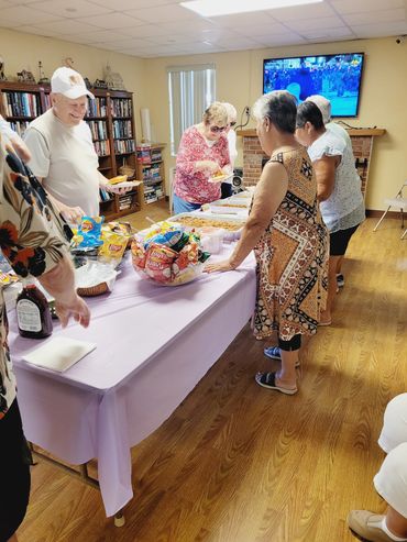 Seniors enjoying a casual indoor buffet meal in a cozy room.