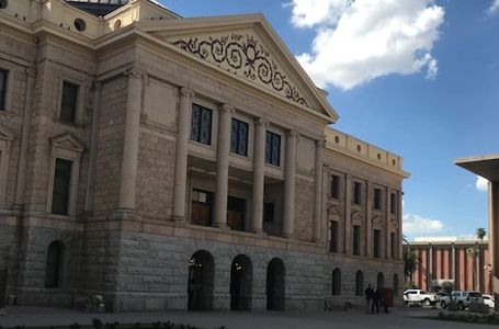 Historic building with intricate facade under a bright blue sky.