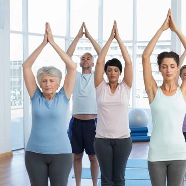 Diverse group of people practicing yoga, in  upward salute pose