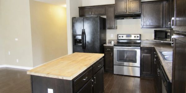 Modern kitchen with dark wood cabinets and appliances.