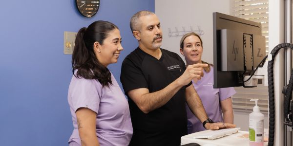 Medical professionals reviewing information on a computer screen.