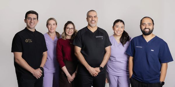 Group of six diverse healthcare professionals posing together.