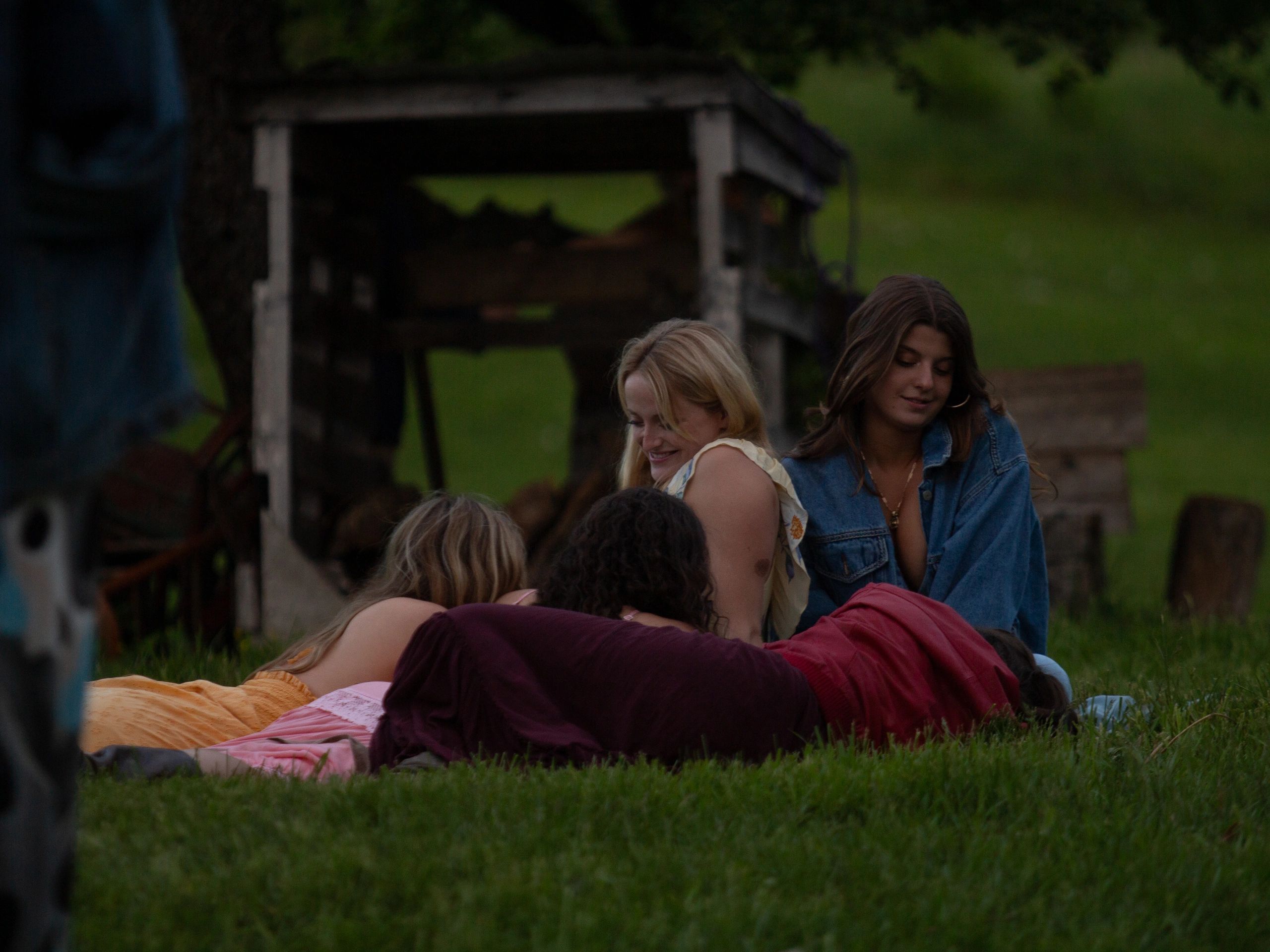 A group of friends lying on grass outdoors, enjoying a relaxed moment.