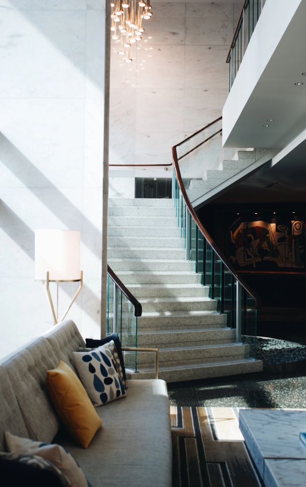 The natural light beams onto a glass enclosed stairwell leading into the first floor living space. 