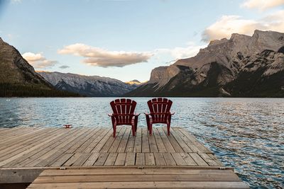 Two red chairs on a dock. Photo by Andre Furtado.