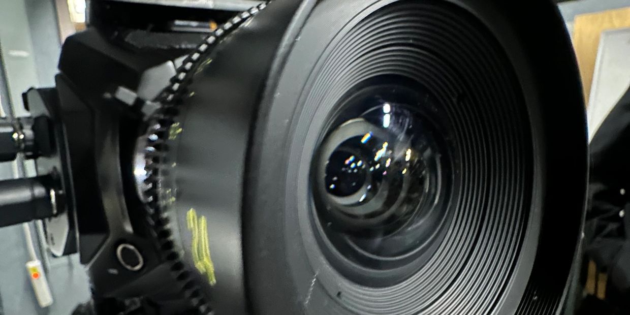 Close-up of a professional camera lens with detailed focus rings.