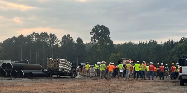 Group of employees at a sitewide safety meeting going over safety protocols. 