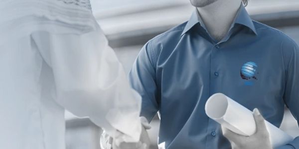 Two men shaking hands, one holding blueprints.