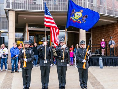 Color guard holding American and state flags at a public event.