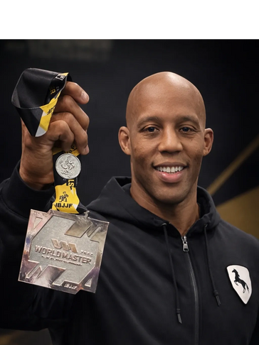 Man proudly holding a silver IBJJF World Master medal.