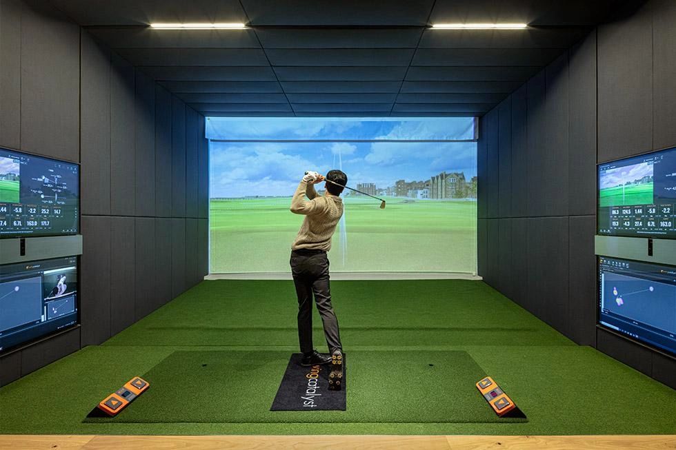 Person playing golf in a simulator room.
