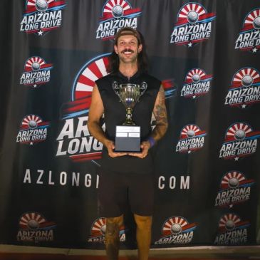 Smiling man holding a trophy at Arizona Long Drive event.