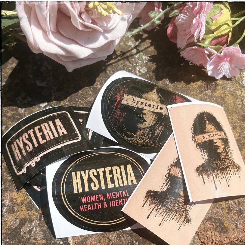 Stickers with 'Hysteria' theme and floral decorations on a stone surface.