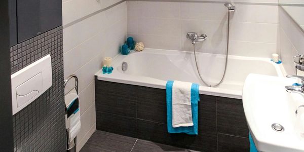 Modern bathroom with white and blue accents and sleek fixtures.