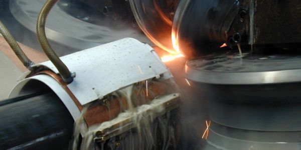 Industrial grinding process with sparks and cooling fluid.