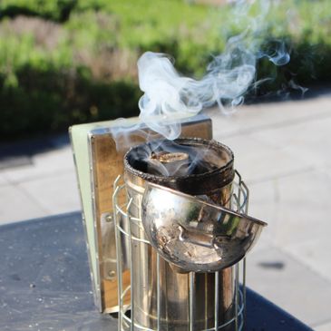 Un enfumoir à abeilles dégageant de la fumée.