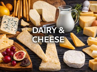 A variety of cheeses, milk, fruits, and breadsticks arranged on a wooden surface.