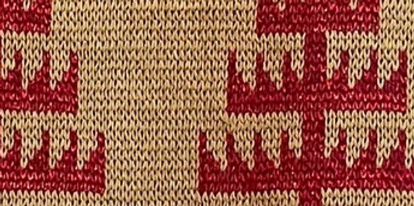Close-up of knitted fabric with red and beige pattern.