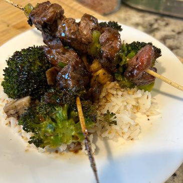 Teriyaki and green onion Beef skewers over a bed of rice