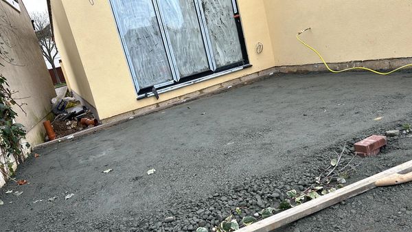 Newly poured concrete patio area outside residential sliding doors.
